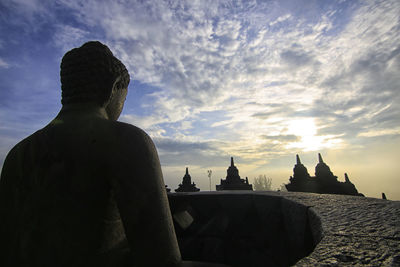 Statue of historic building against sky during sunset