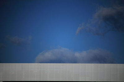 Low angle view of smoke stack against sky on sunny day