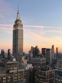 Skyscrapers in city at sunset