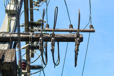 Low angle view of birds perching on pole against sky