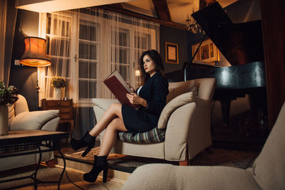 Young woman sitting on sofa at home