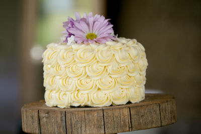 Close-up of wedding cake on wooden stand