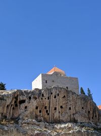Low angle view of historic building against blue sky