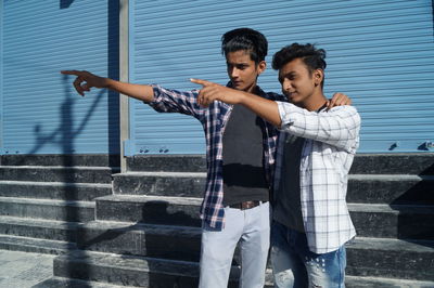Portrait of smiling young man standing against wall