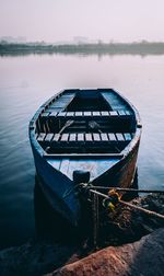 Boat moored on lake against sky