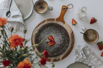 Freshly baked chocolate cake with strawberries on table