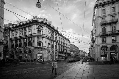 Buildings in city against cloudy sky