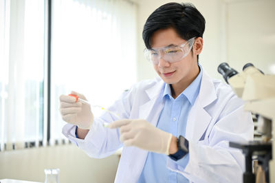 Female doctor examining chemical in laboratory