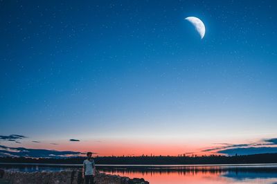 Scenic view of lake against sky at night