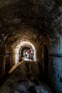 Rear view of people standing in tunnel