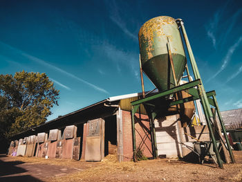 Low angle view of water tower against blue sky