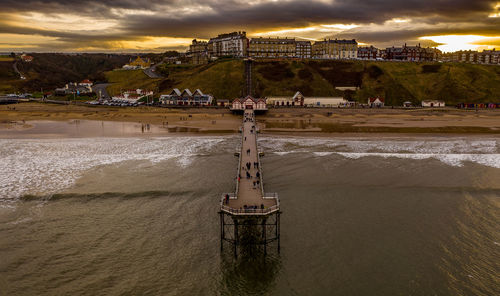 High angle view of pier over sea against cloudy sky during sunset