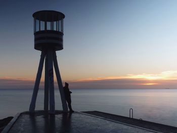 Pier on sea at sunset