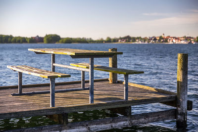 Pier on table by lake against sky