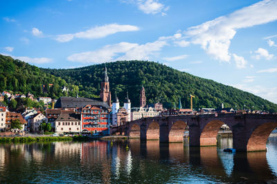 Old german town reflecting onto river. mountains in the background.