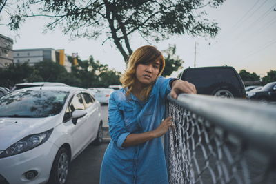 Young woman standing by car