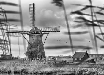 Traditional windmill on field against sky