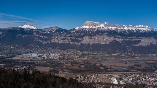 High angle view of snowcapped mountains against blue sky