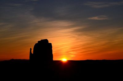 Silhouette rock against sky during sunrise