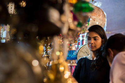 Close-up of young woman standing outdoors at night