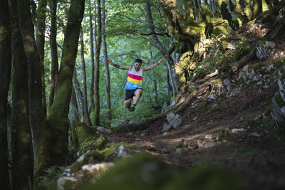 Trailnunner running on mountain trail at forest