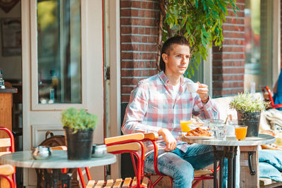 Young man sitting at restaurant table