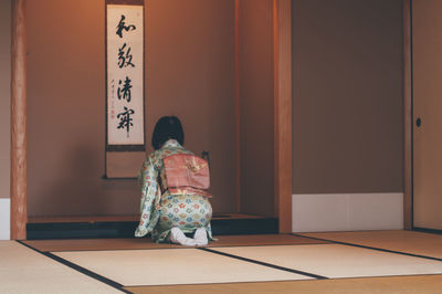 Rear view of woman standing against door