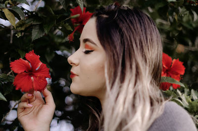 Close-up of woman with red flower