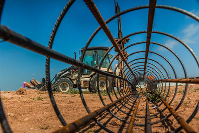 Metallic structure on field against sky