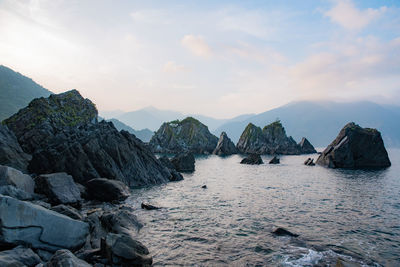 Panoramic view of rocks in sea against sky