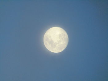 Low angle view of moon against clear blue sky