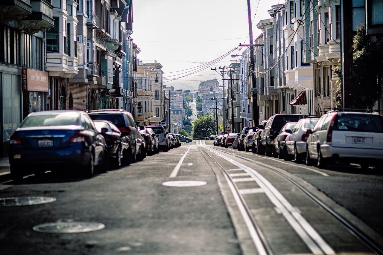 transportation, car, land vehicle, building exterior, mode of transport, architecture, street, built structure, city, road, the way forward, diminishing perspective, road marking, city street, traffic, vanishing point, city life, building, incidental people, day