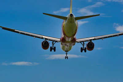 Low angle view of airplane flying against sky