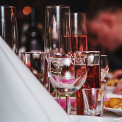 Square picture of shiny glasses on a festive table with a white cloth napkin in a corner