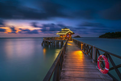 Pier over sea against sky during sunset