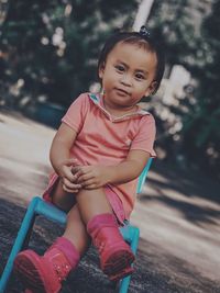 Portrait of cute girl sitting outdoors