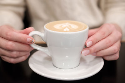 Midsection of woman holding coffee cup