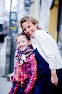 Portrait of cheerful grandmother and granddaughter in city