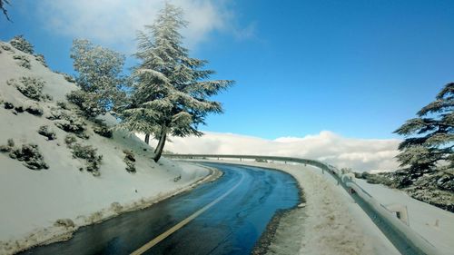 Scenic view of snow covered road against sky