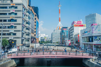 Bridge over canal amidst buildings in city against sky