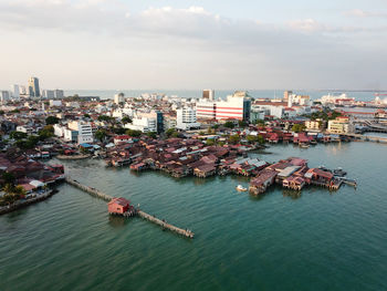 High angle view of cityscape by sea against sky