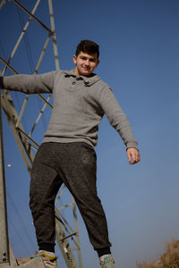 Portrait of young man against clear sky