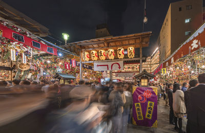 People on illuminated street market at night