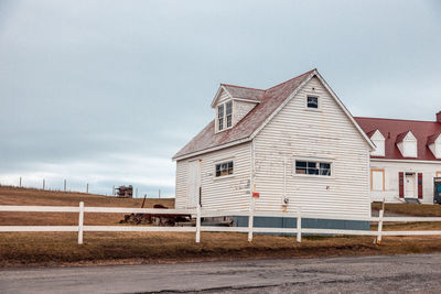 Houses by road against sky in city