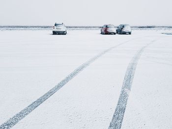 Cars on road by sea during winter