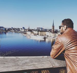 Panoramic view of statue by river against buildings in city