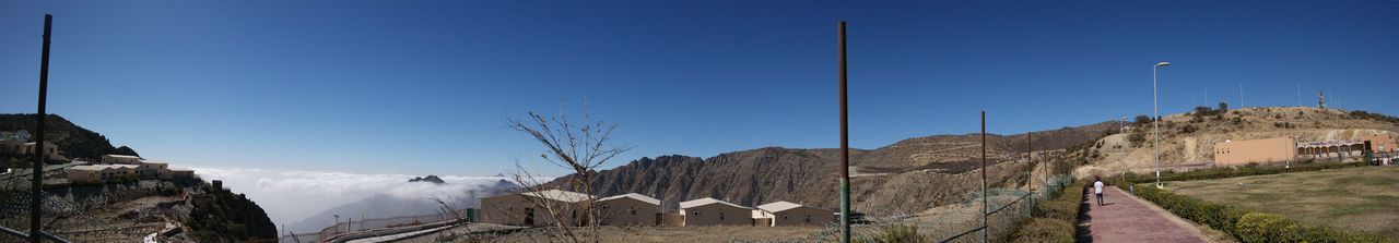 Panoramic view of buildings against clear blue sky