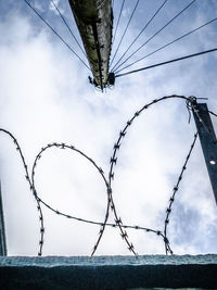 Low angle view of barbed wire against sky