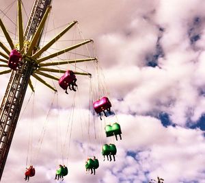 Low angle view of ferris wheel against cloudy sky
