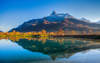 Mountain reflecting on calm lake during autumn